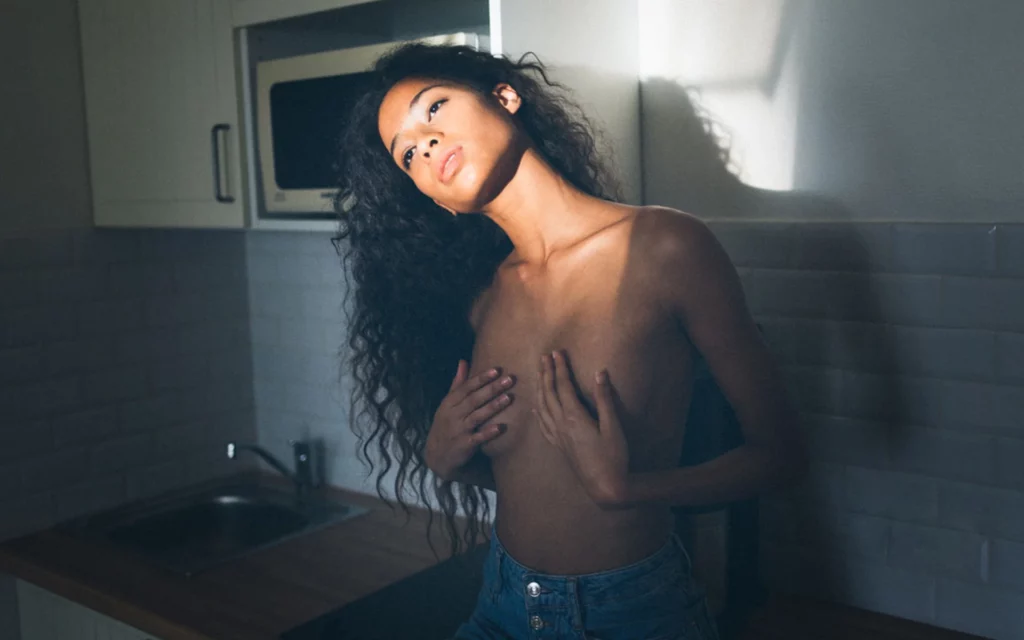 Portrait d'une femme près d'une fenêtre dans une cuisine photographiée par Antoine Cassane.