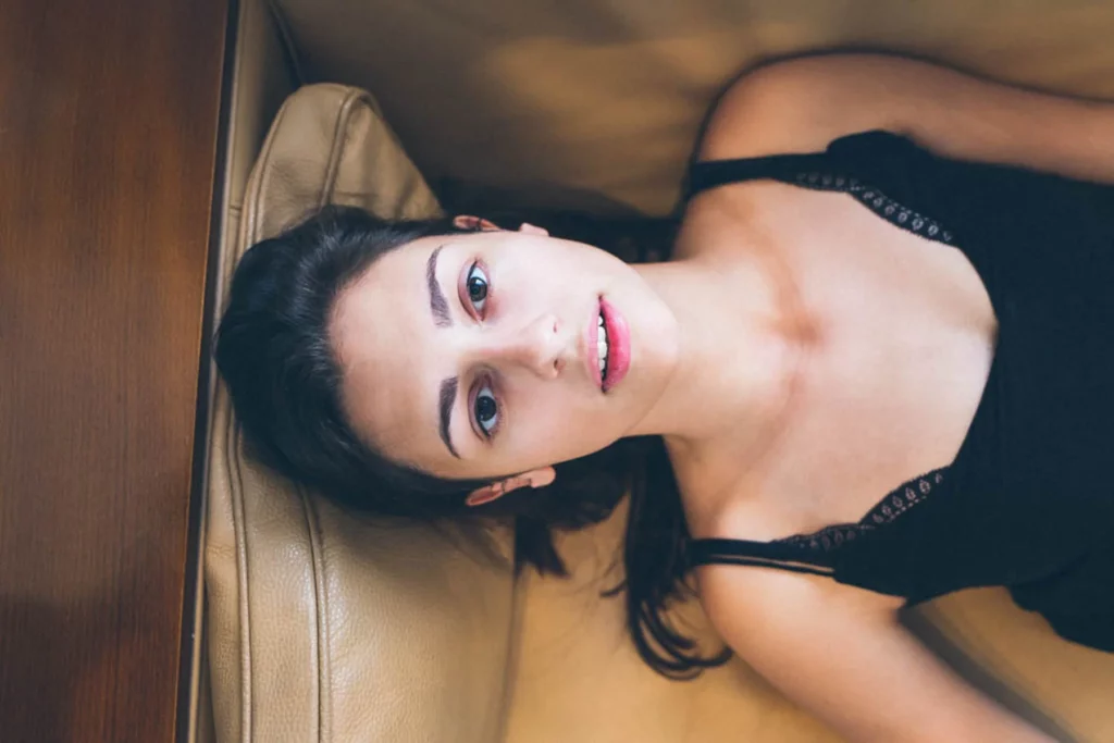 Portrait rapproché d'une femme allongée regardant l'objectif photographiée par Antoine Cassane.