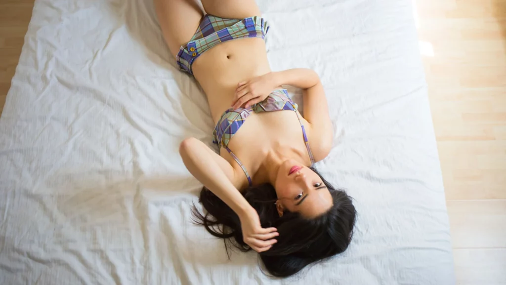 Portrait intimiste d'une femme allongée sur un lit en lingerie photographié par Antoine Cassane.