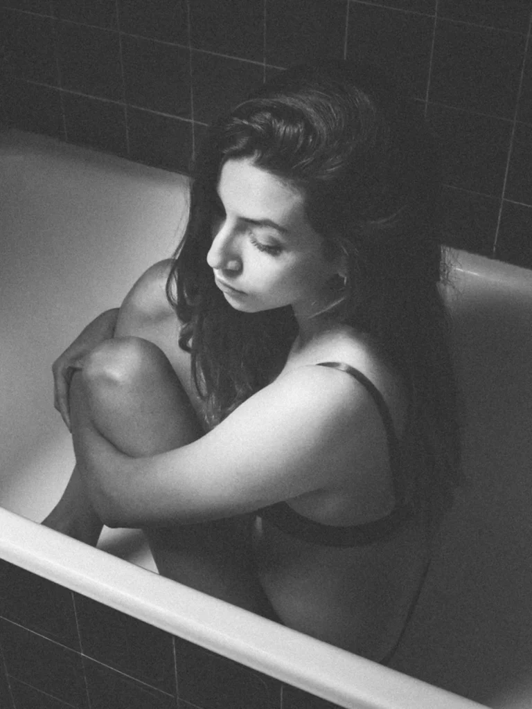 Portrait en noir et blanc d'une femme assise dans une baignoire photographiée par Antoine Cassane.