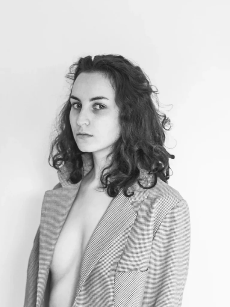 Portrait en noir et blanc d'une femme portant une veste ouverte, réalisé par le photographe Antoine Cassane.