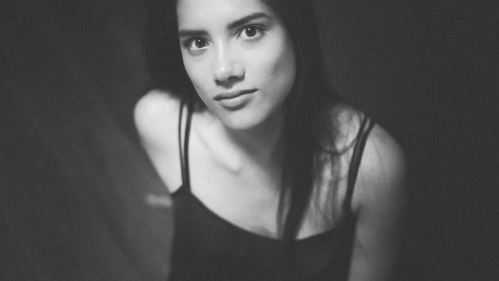 Portrait en noir et blanc d'une femme assise regardant directement l'objectif, réalisé par le photographe Antoine Cassane.