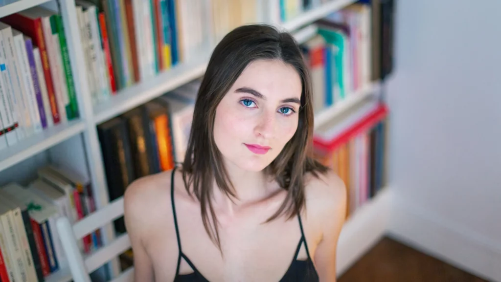 Portrait d'une femme devant une bibliothèque, réalisé par le photographe Antoine Cassane.