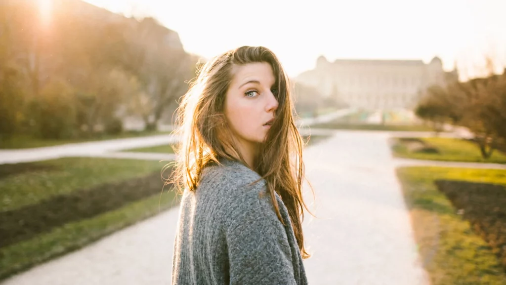 Portrait d'une femme en extérieur baignée par la lumière dorée du soleil, photographié par Antoine Cassane.